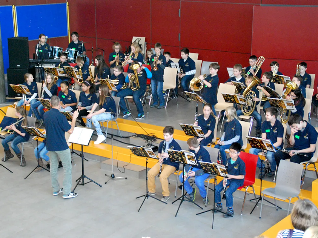 Blick von oben auf das spielende Blasorchester in der Pausenhalle.